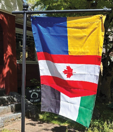 A multi-nation solidarity flag flying outside a house
