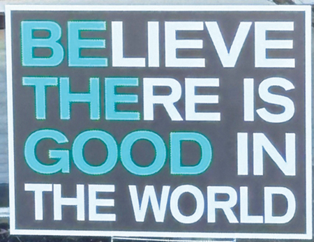 A yard sign reading 'Believe there is good in the world'