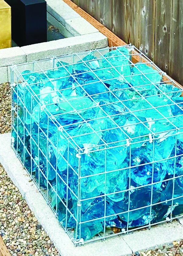 A blue-glass sculpture in a front garden.